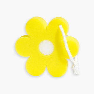 Image of Beekman 1802's Bloom Sponge that's in the shape of a yellow daisy with a white strong attached to the top on a grey background.