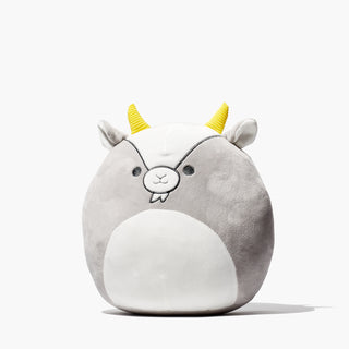 Beekman 1802's Goatie Squishmallow which is in the shape of a cartoon goat with yellow horns, on a white background.