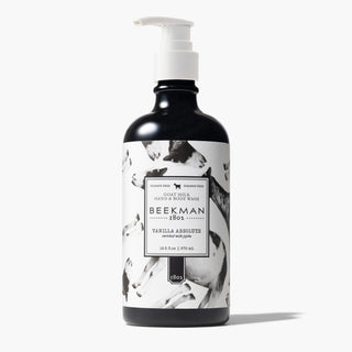 Bottle of Beekman 1802's Hand & Body Wash with a white nozzle on a grey background.