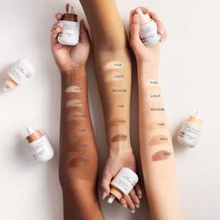 Image of 3 arms holding Beekman 1802 Milk Tint SPF 43 Tinted Primer Serum with all 6 shade swatches on each arm.