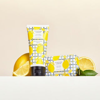 Sunshine lemon 2 oz hand cream and 3.5 oz bar soap in front of sliced lemons.
