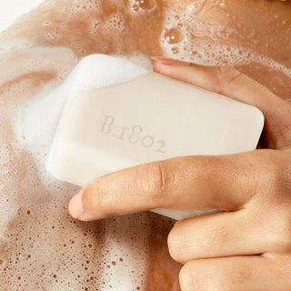 Model rubbing fresh air 3.5 oz bar soap onto shoulder covered in suds.