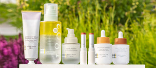 Image of Beekman 1802 SPF products all lined up next to each other, with green garden and plants in the background.