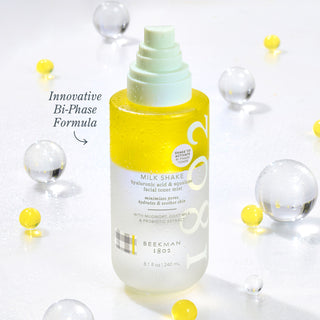 Beekman 1802 Full Size Milk Shake Toner Mist surrounded by clear and yellow spheres with the words "innovative Bi-Phase Formula" next to the bottle.