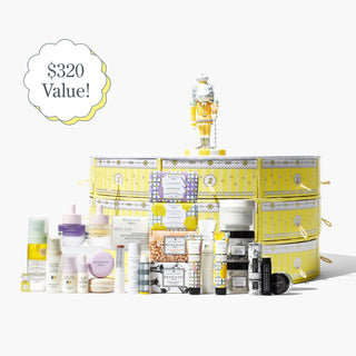 Beekman 1802's Slice of Kindness Advent Calendar which shows the yellow advent calendar in the back with the goatie cake topper on top of it, and all the products that comes inside it stacked up in front of the advent calendar, on a white background.