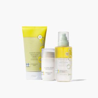 Beekman 1802's Simply the best bundle which shows the Sunshine scrub, bloom cream, and milk shake on a gray background.