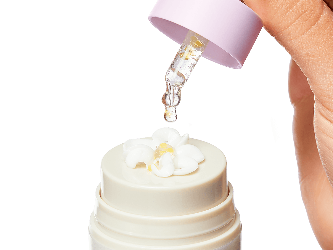 An image of the Collagen Booster serum being dropped into a bloomed Bloom Cream with the serum and moisturizer mixed together on top of the Bloom Cream bottle. 