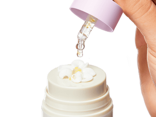 An image of the Collagen Booster serum being dropped into a bloomed Bloom Cream with the serum and moisturizer mixed together on top of the Bloom Cream bottle. 