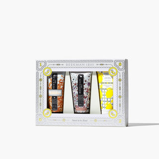 Gift box set of Beekman 1802's Knead A Hand? 3-Piece Hand Cream Sampler, which shows the honey and orange blossom, honeyed grapefruit, and sunshine lemon goat milk hand creams in the front, on a white background.