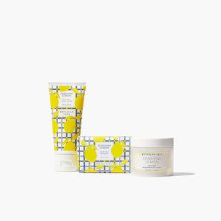 Tube of Beekman 1802's hand cream, bar of soap, and jar of whipped body cream all in the Sunshine Lemon scent and lined up next to each other, on a white background.