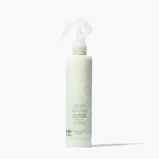 Bottle of Beekman 1802's Goat Milk Hair Mist Leave-In restorative & volumizing treatment on a white background with shadow.