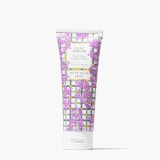 Full-Size Tube of Beekman 1802's Lilac Dream Hand Cream that is designed with blue and grey gingham and pruple lilac flowers, standing on a white background.