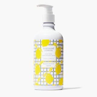 Bottle of Beekman 1802's Sunshine Lemon 12.5 oz Hand & Body Wash, with a gingham label decorated in lemon and white nozzle, standing on a white background. 