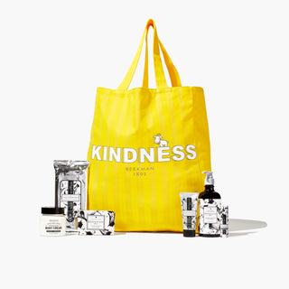 Image of beekman 1802's 2023 Holiday Goat Getter tote which shows 6 vanilla absolute bodycare items in front of the 2023 holiday tote bag that's in the color sunshine yellow with the words "Kindness, Beekman 1802," on the front, on a white background.