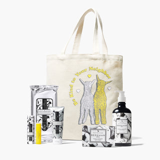 Beekman 1802's spring 2024 Seasonal Fragrance Tote bundle which features an assortment of vanilla absolute products standing in front of a beige tote with and yellow goat and white goat  on the front and words saying "be kind to your neighbor," standing on a white background. 