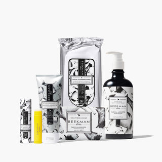 Assortment of Beekman 1802's Vanilla absolute products, which show a lip balm, hand cream, goat milk soap, face wipes, and hand & body wash all lined up next to each other in that order, on a white background. 