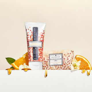Honey and orange blossom 2 oz hand cream and 3.5 bar soap surrounded by sliced oranges with honey dripping off them.