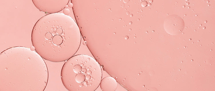 Up close shot of PHA ingredient colored pink in liquid form with small bubbles formed. 