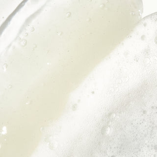 Up close texture shot of Beekman 1802's Vegan Goat Milk™ Oil Eliminating Foaming Gel Cleanser, which is white and has tiny bubbles in it.