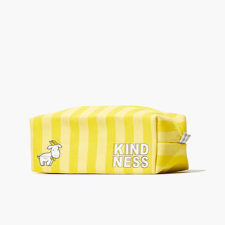 Front side of yellow Beekman 1802 striped dopp bag, which has the word "Kindness" and an image of a cartoon goatie on the front, on a white background.