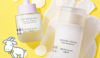 Bottle of Beekman 1802's Bloom Cream Daily Moisturizer and Oh! Mega Milk Facial Oil on a yellow background next to their texture swipes and an image of a white cartoon Goatie on the bottom left.