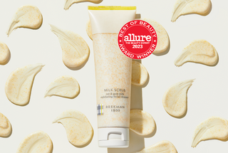 Tube of Beekman 1802's Milk Scrub Oat + Goat Milk Exfoliating Cleanser on a eggshell background surrounded by product texture swatches, next to a red seal that says "Allure 2023 Best of Beauty Award Winner."