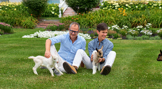 Beekman 1802 founders, Josh and Dr. Brent, playing with goats outside at the Beekman Farm