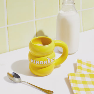 Video of Beekman 1802's Ceramic Kindness Mug on a counter top next to a glass jug with milk, with a hand grabbing the jug and pouring the milk into the mug.