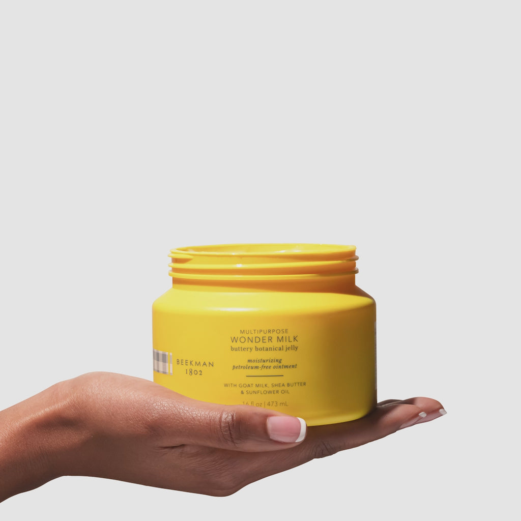 Video of hand holding the beekman 1802 Wonder Milk Buttery Botanical Jelly while scooping out product with their other fingers.