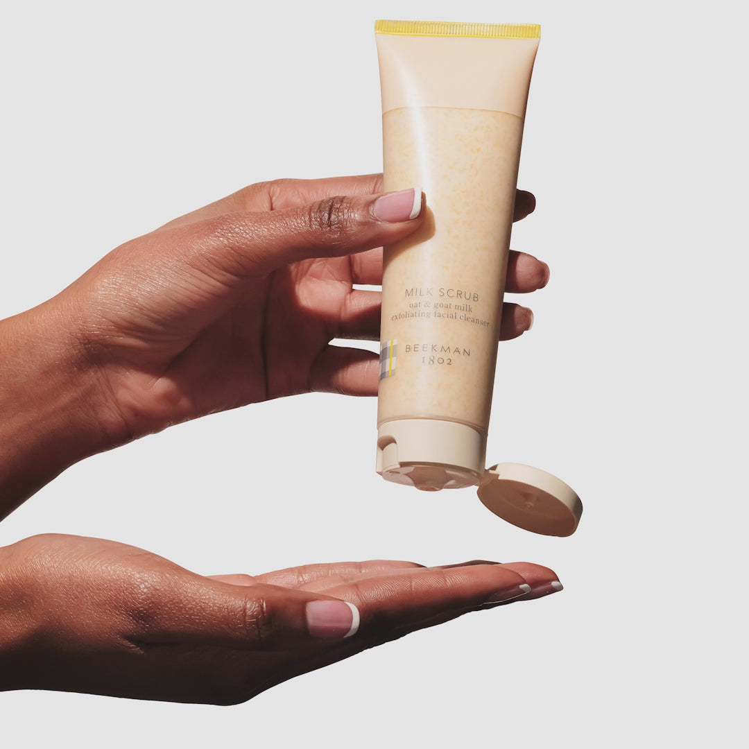 Video of hand squeezing the beekman 1802 Milk Scrub Oat + Goat Milk Exfoliating Facial Cleanser onto their other hand.
