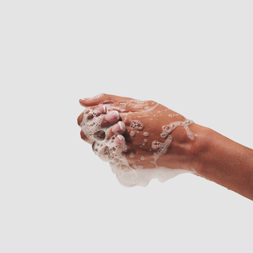 Up close GIF of two hands using Beekman 1802's goat milk hand & body wash and rubbing together to create suds, on a white background. 