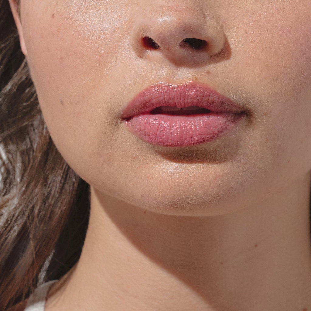 Upclose Gif of models lips while applying beekman 1802's Rosy Posy SPF 15 Goat Milk Tinted Lip Cream to her lips.