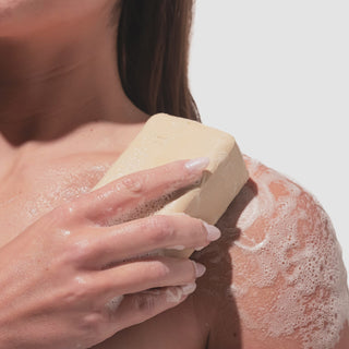 Video of model rubbing the beekman 1802 Golden Vitamin C & Amla Berry Goat Milk Soap onto their shoulder.