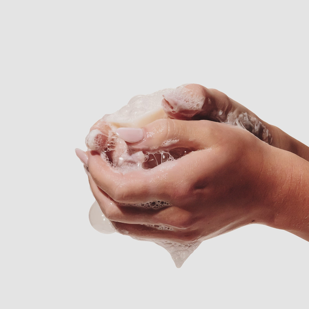 Video of hands rubbing a sudsy  beekman 1802 Milk Bar Facial Cleansing bar.