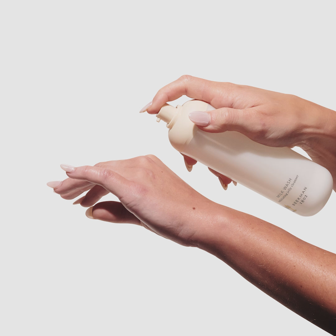 Video of hand pumping one pump of the beemkan 1802 Milk Wash Exfoliating Jelly Cleanser onto the back of their other hand and rubbing it in.
