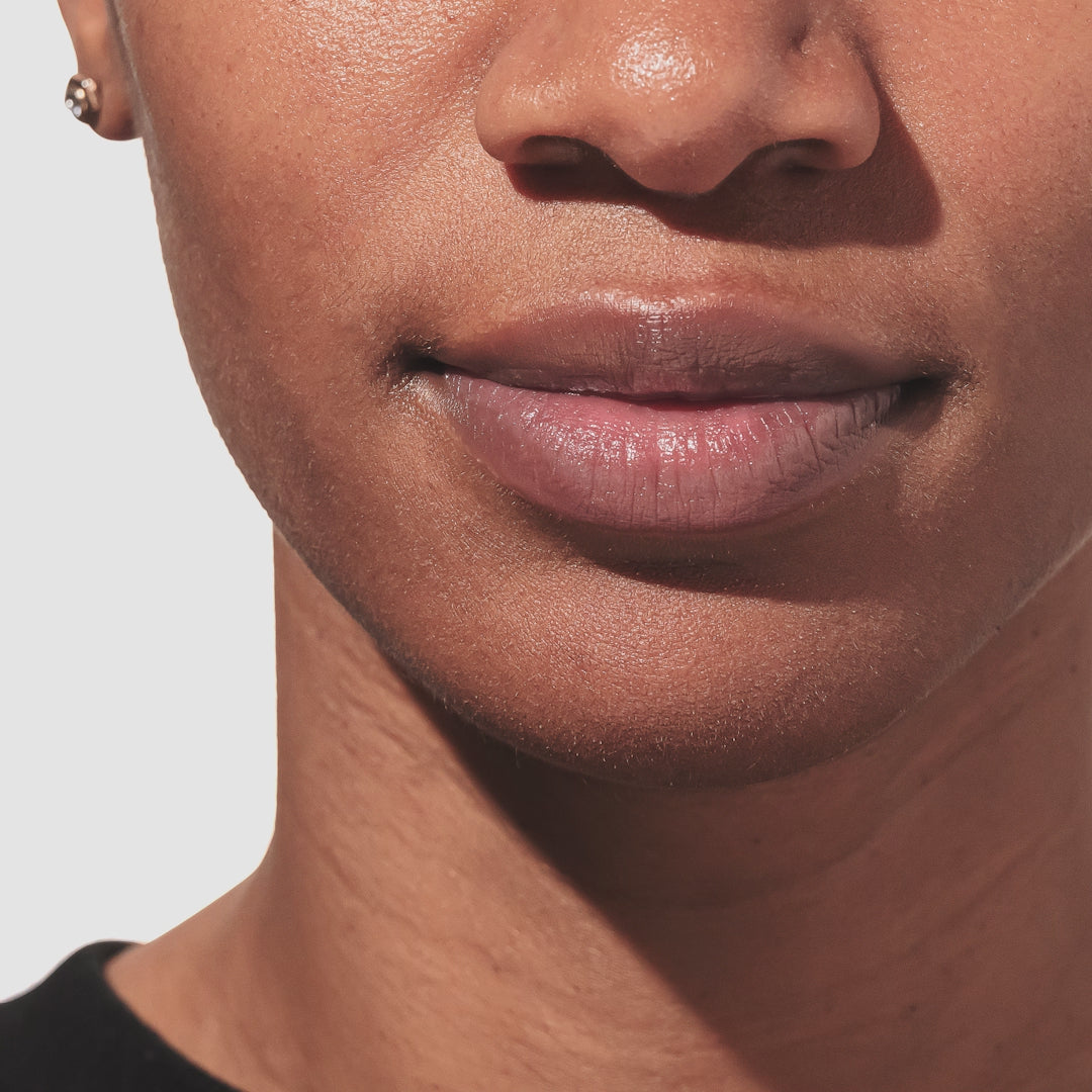 An up close video of a model applying the beekman 1802 Pure lip balm to their lips.